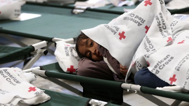 A young girl keeps warm under her blanket at the new Casa del Refugiado in east El Paso, Texas.