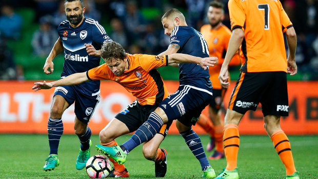 Brett Holman (orange) and Melbourne Victory’s James Troisi (blue) contest the ball in the 2017 A-League semi-final at AAMI Park.