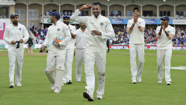 Ovation: Indian cricketers applaud teammate India's Hardik Pandya, holding the ball, after his five-wicket haul against England.