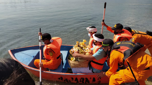 National Search and Rescue Agency personnel help relatives of Captain Gede Kartika, one of the junior officers on the KRI Nanggala, to carry offerings to the sea during a prayer in Celukan Bawang, Bali. 