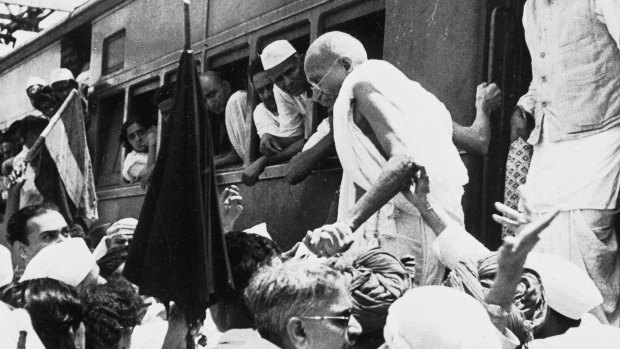 National Congress Party leader Mahatma Gandhi, center, disembarks from a train in Bombay, India on October 5, 1944.