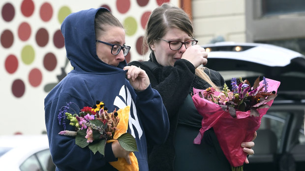Unidentified people bring flowers to the scene where 20 people died when a limousine crashed into an car in Schoharie, New York.