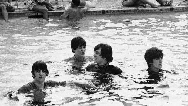 From left: Ringo Starr, Paul McCartney, John Lennon and George Harrison take a dip in the pool in the Bahamas with their clothes on while filming a movie, 1965.