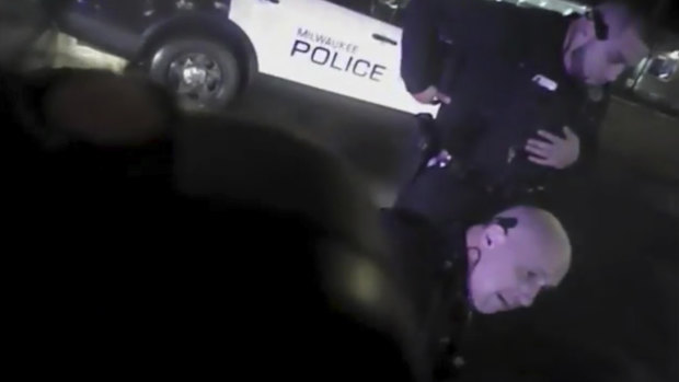Brown is held on the ground by Milwaukee Police Department officers.