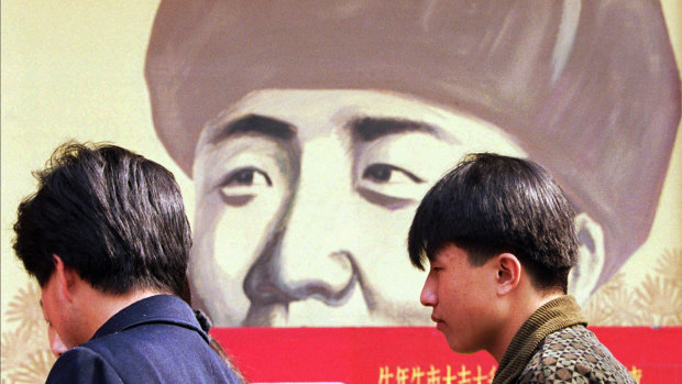In this 1997 file photo, Chinese wait outside a movie theatre featuring a poster promoting a movie about Feng.