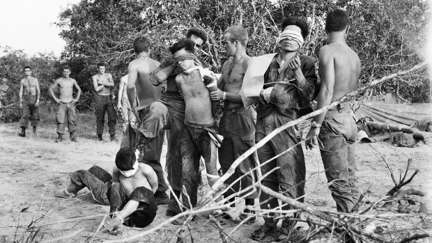 Bien Hoa Province, South Vietnam: Blindfolded North Vietnamese soldiers captured on May 28, 1968, await helicopters to take them from the battle area.
