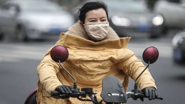 A woman wears a mask in Wuhan, which has been linked to cases of the new coronavirus.