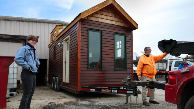 A happy Meghan Panu watches as Mark Ives, owner of Ives Towing, hooks up her recovered tiny house on his Hillsboro lot for its trip home.