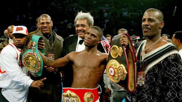 Cory Spinks (with belts) poses with his promoter Don King (centre back), uncle Michael (right) and father Leon (left) after the undisputed welterweight championship bout in New Jersey.