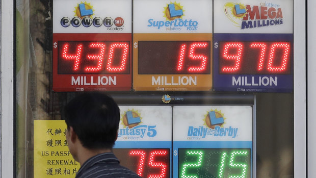 A man walks past Mega Millions and other lottery displays outside The Lucky Spot in San Francisco on Thursday.