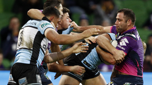 Gridlock: Storm skipper Cameron Smith gets caught up in heavy traffic taking on the Sharks' defence.