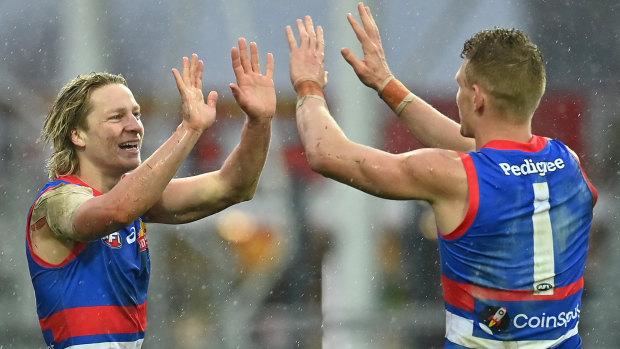 Cody Weightman of the Bulldogs is congratulated by Adam Treloar at a wet Launceston.