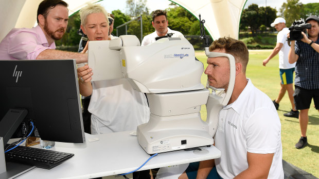 Eye-opener: Aaron Finch gets his eyes tested at Allan Border field in Brisbane yesterday.