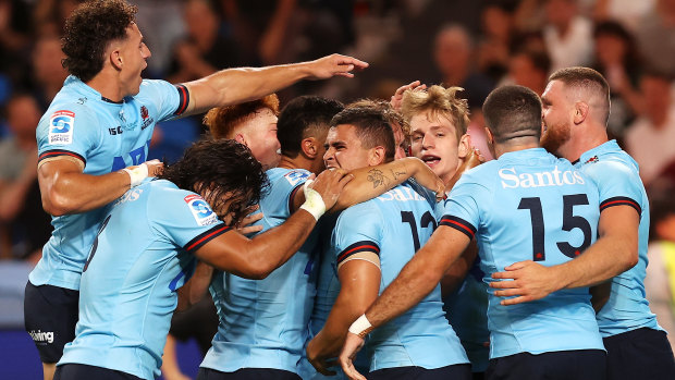 Waratahs players swamp Max Jorgensen after he scores against the Brumbies.