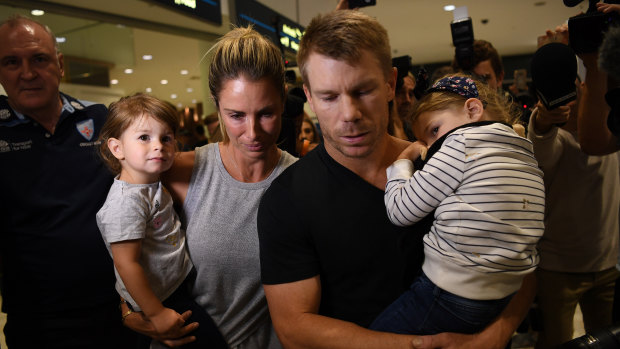 Rough landing: David and Candice Warner arrive at Sydney Airport with their two children on Thursday.