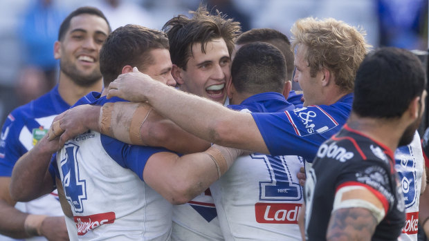 Fairytale match: Lachlan Lewis is mobbed after scoring a try, but before sealing victory with a field goal.