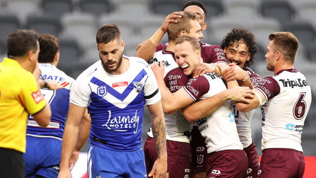 Tom Trbojevic celebrates one of his three tries with Sea Eagles teammates as Manly belted the Bulldogs 66-0.