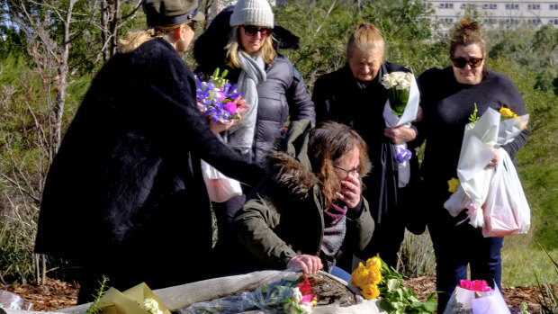 Courtney Herron's mother weeps at the site of her death in Royal Park as her grandmother and other family members stand by. 