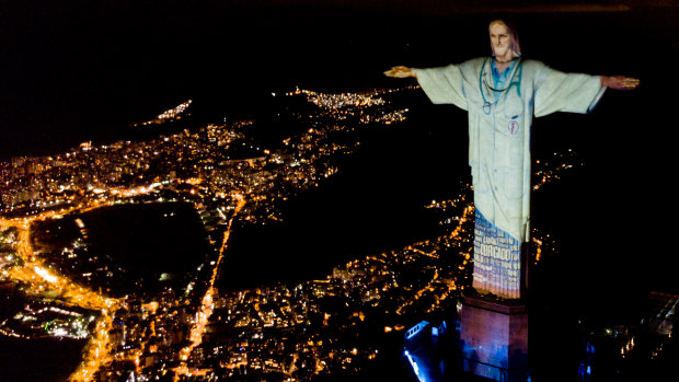 Illuminated statue of Christ the Redeemer that reads "Thank you" as Archbishop of the city of Rio de Janeiro Dom Orani Tempesta performs Mass on Easter Sunday.