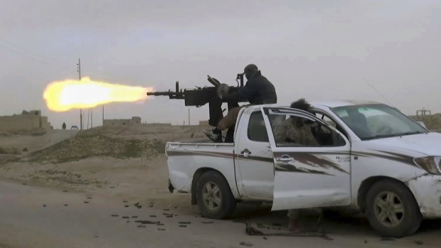 This frame grab from video posted online in January by supporters of the Islamic State group, purports to show a gun-mounted Islamic State group vehicle firing at members of the US-backed Syrian Democratic Forces, in the eastern Syrian province of Deir el-Zour, Syria.