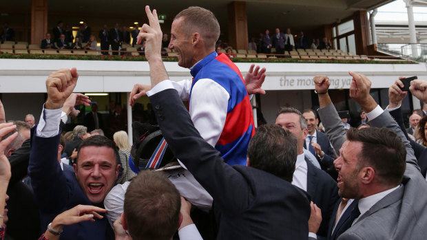 Jockey Damien Oliver is mobbed by winning owners after Steel Prince's narrow win on Saturday.