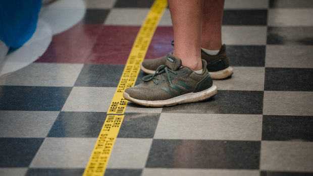 A man stands in line behind social distancing tape at a polling station in Philadelphia, Pennsylvania.