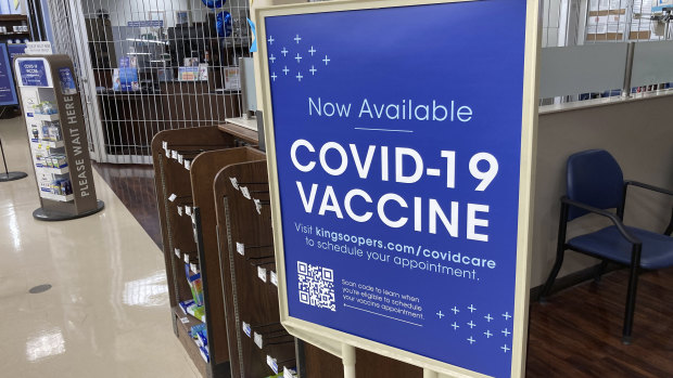 A sign notifies customers that COVID-19 vaccinations are available at a pharmacy in a grocery store in Monument, Colorado.