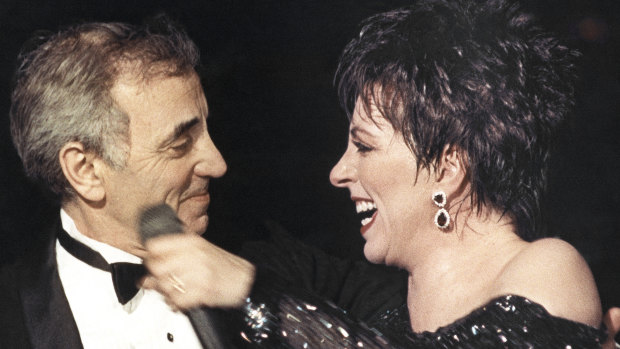 Liza Minnelli welcomes Charles Aznavour onto the stage at the end of her show at the Lido cabaret in Paris in 1987.
