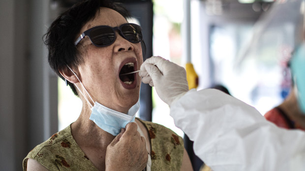 A medical worker takes samples during a mass COVID-19 test in a residential block in Wuhan.