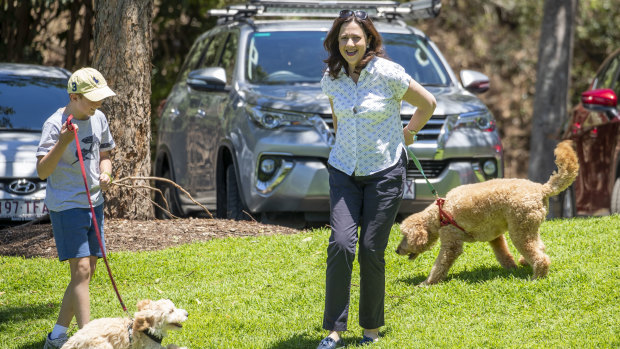 Premier Annastacia Palaszczuk with her dog Winton and her nephew Harry and his dog Oakey before a press conference at Rocks Riverside Park in Brisbane on Sunday.