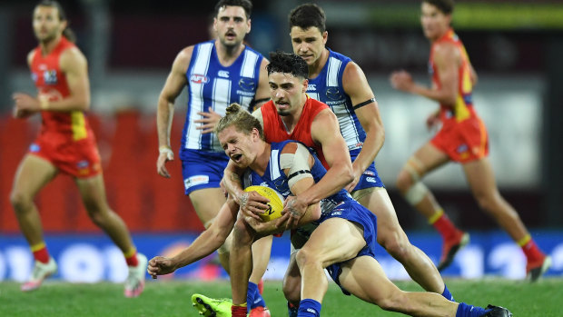 Block and tackle: North Melbourne's Jed Anderson is brought down by Gold Coast's rising star Izak Rankine.