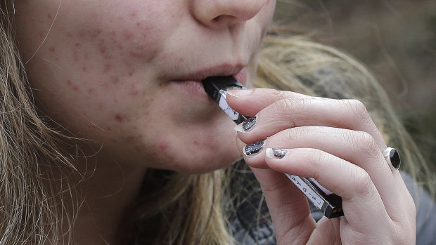 A high school student uses a vaping device near a school campus in Cambridge, Massechusetts. 