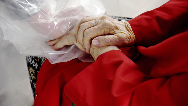 Gregg MacDonald holds hands with his 84-year-old mother, Chloe MacDonald, at the “hug tent”.