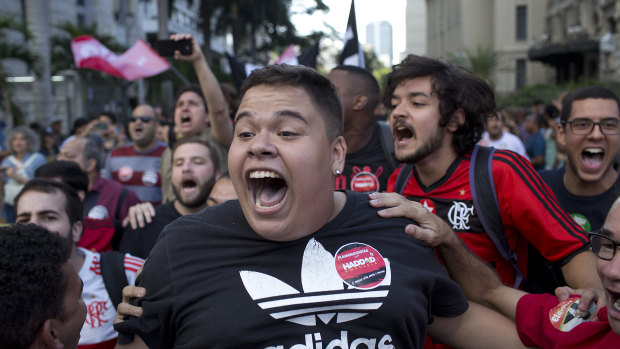 Soccer fans and supporters of Workers' Party presidential candidate Fernando Haddad shout slogans during a demonstration at Cinelandia square, Rio de Janeiro, Brazil.