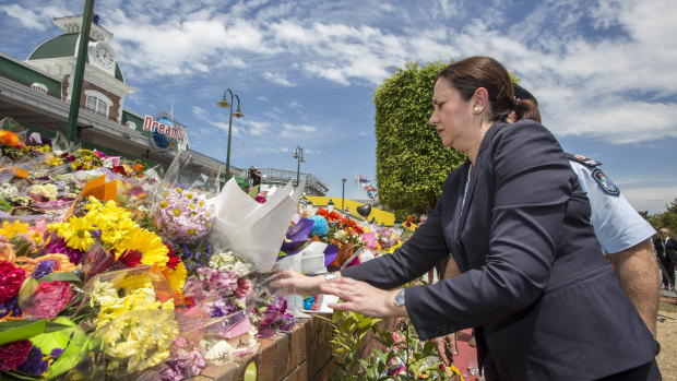 Queensland Premier Annastacia Palaszczuk places flowers at the makeshift memorial outside Dreamworld in 2016.