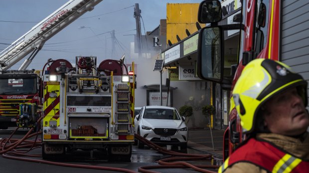 Fire crews outside the Clark Rubber shop front in Niddrie on Saturday. 