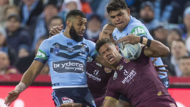 Dane Gagai of the Maroons (right) grabs the ball from a high kick in a tackle from Josh Addo-Carr of the Blues.