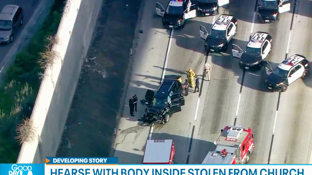 Los Angeles police officers at the scene of the end of a pursuit of a hearse with a body inside in South Los Angeles.