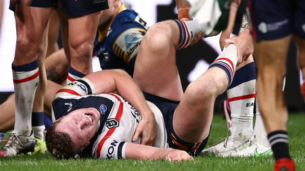 Drew Hutchison of the Roosters writhes in pain. He was sent to hospital with suspected broken ribs. 