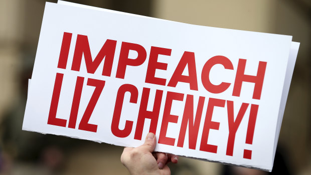 A protester holds an “Impeach Liz Cheney” sign during a rally against her in Wyoming in January. 