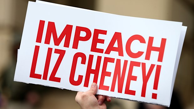 A protester holds an “Impeach Liz Cheney” sign during a rally against her in Wyoming in January. 