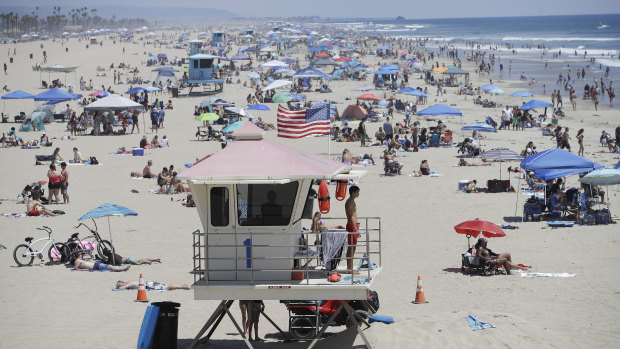 A lifeguard keeps watch over a packed beach in Huntington Beach on Monday.
