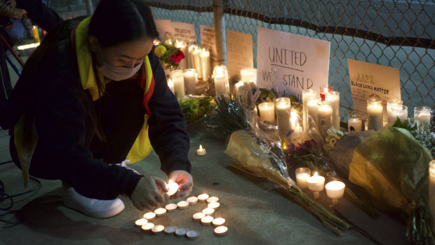 A woman lights candles at a rally “Stop Asian Hate” candlelight vigil in Alhambra, California.