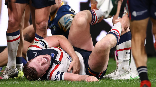Drew Hutchison of the Roosters writhes in pain. He was sent to hospital with severe injuries. 