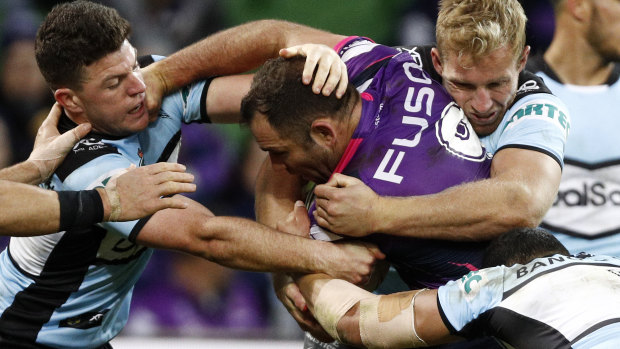 Hitting the wall: Cameron Smith is wrapped up by the Sharks at AAMI Park. 