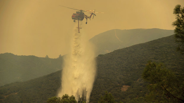A Cal Fire helicopter helps battle a wildfire in Spring Valley, California on Sunday.
