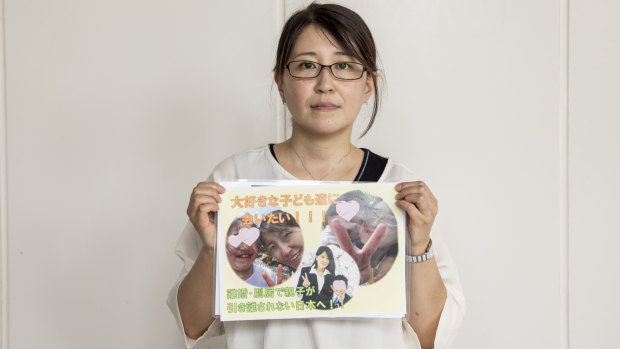 Izumi Dobashi with a photo of her three children. 