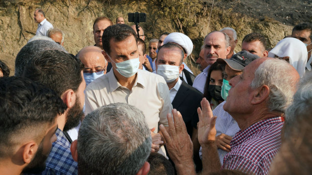Syrian President Bashar Assad speaks with people during his visit to the coastal province of Latakia, Syria after the wildfires in 2020. 
