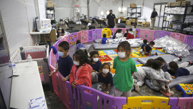 Young unaccompanied migrants, from ages 3 to 9, watch television inside a playpen at the US Customs and Border Protection facility in the Rio Grande Valley, in Donna, Texas.