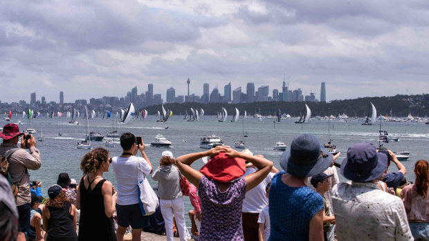 Crowds watch from South Head as the Sydney to Hobart fleet depart.